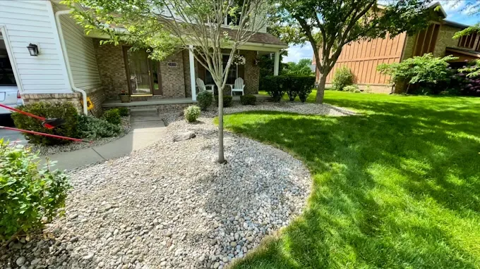 Front yard with stone landscape bed and healthy lawn